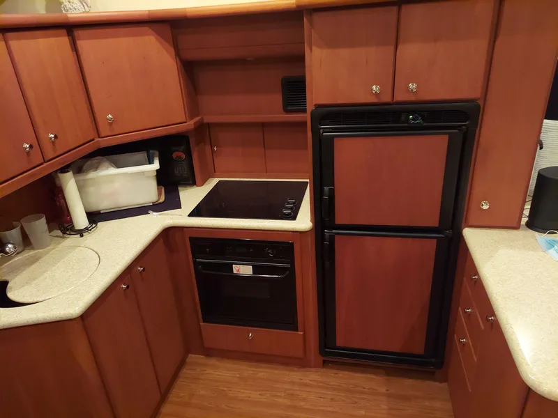 Slide: The Image of 2005 Silverton 43 Motor Yacht kitchen with wood cabinets and modern appliances. - 15