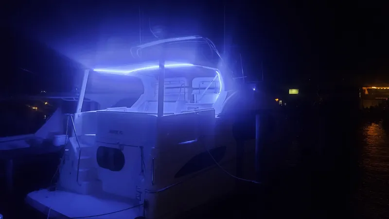 Slide: The Image of 2005 Silverton 43 Motor Yacht illuminated with blue lights at night. - 6