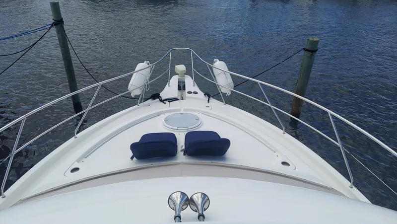Slide: The Image of 2005 Silverton 43 Motor Yacht bow view with water and dock posts. - 7