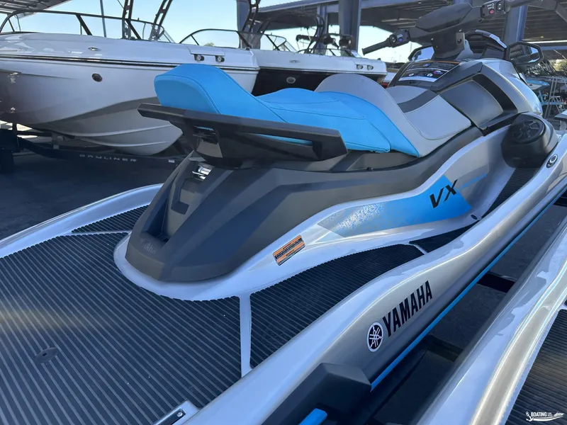 Slide: The Image of 2024 Yamaha WaveRunner VX Cruiser with Audio, sleek design, blue seat, docked near boats. - 9
