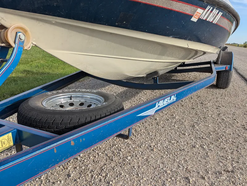 Slide: The Image of 1996 Javelin 379 F/S boat on a blue trailer with spare tire. - 11