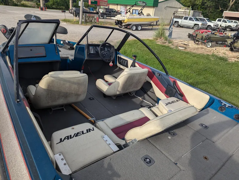Slide: The Image of 1996 Javelin 379 F/S boat interior with seating and steering wheel, parked outdoors. - 13