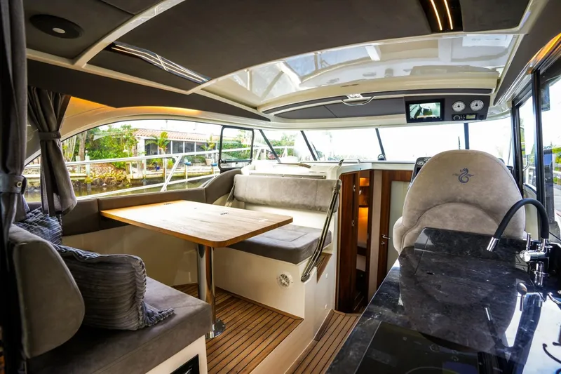 Slide: The Image of Interior of 2025 Marex 330 Scandinavia yacht with modern seating and wooden table. - 19