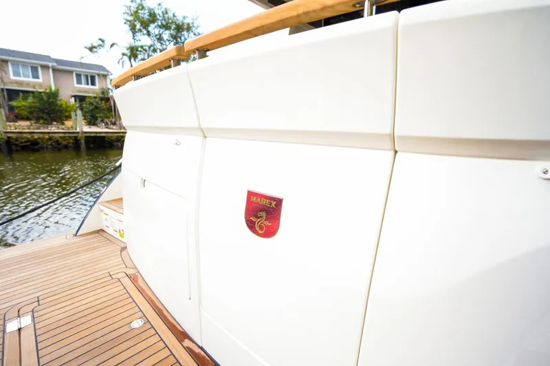 Slide: The Image of 2025 Marex 330 Scandinavia yacht, rear view with emblem, docked by waterfront homes. - 14