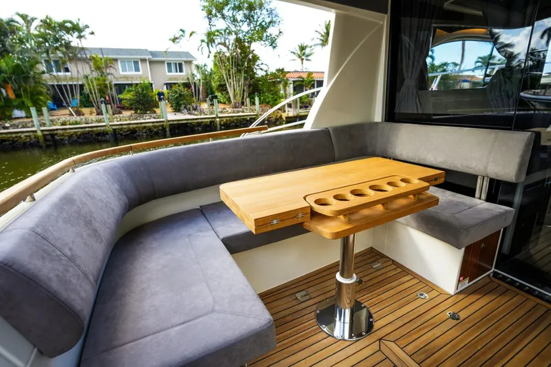 Slide: The Image of 2025 Marex 330 Scandinavia yacht interior with plush seating and wooden table. - 15