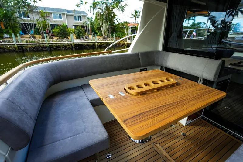 Slide: The Image of 2025 Marex 330 Scandinavia yacht interior with wooden table and gray seating. - 16