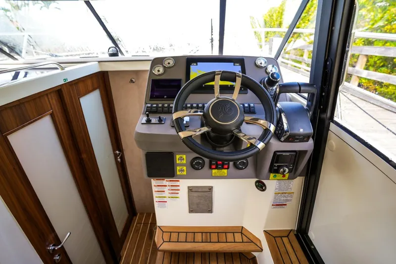 Slide: The Image of Helm of 2025 Marex 330 Scandinavia boat with modern controls and wooden accents. - 26