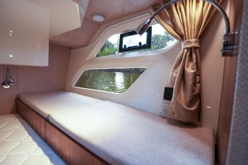 Slide: The Image of Interior cabin of 2025 Marex 330 Scandinavia boat, featuring cozy bed and window view. - 32