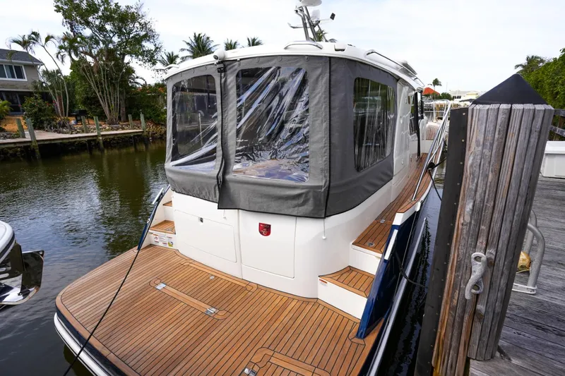 Slide: The Image of 2025 Marex 330 Scandinavia yacht docked, featuring teak deck and enclosed cabin. - 39