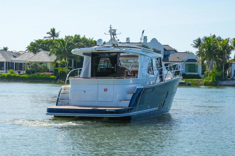 Slide: The Image of 2025 Marex 330 Scandinavia yacht cruising on a serene waterway near luxury homes. - 6