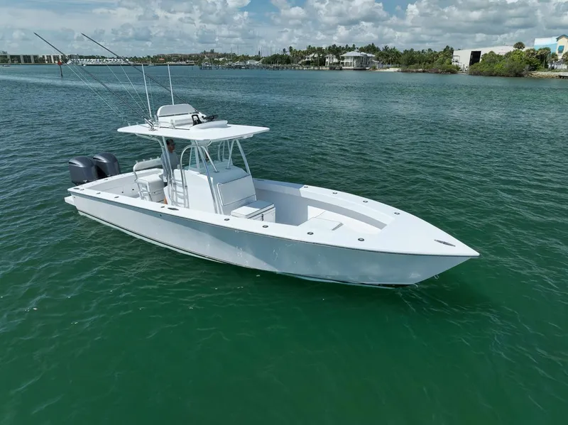 Slide: The Image of 1995 Jupiter 31 Center Console boat on calm water, clear sky background. - 2