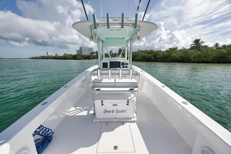 Slide: The Image of 1995 Jupiter 31 Center Console boat on calm water, clear sky, lush greenery. - 20