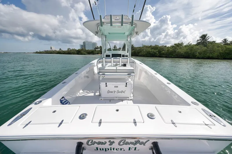 Slide: The Image of 1995 Jupiter 31 Center Console boat on water, clear sky, lush shoreline in background. - 22