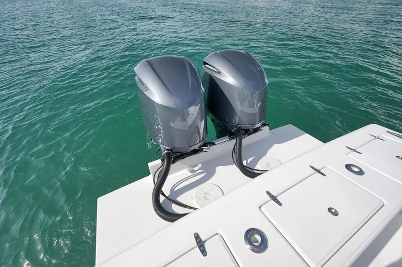 Slide: The Image of Twin outboard engines on a 1995 Jupiter 31 Center Console boat in clear water. - 28