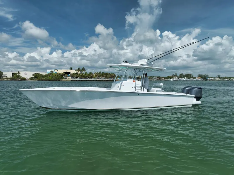 Slide: The Image of 1995 Jupiter 31 Center Console boat on calm water under a partly cloudy sky. - 3