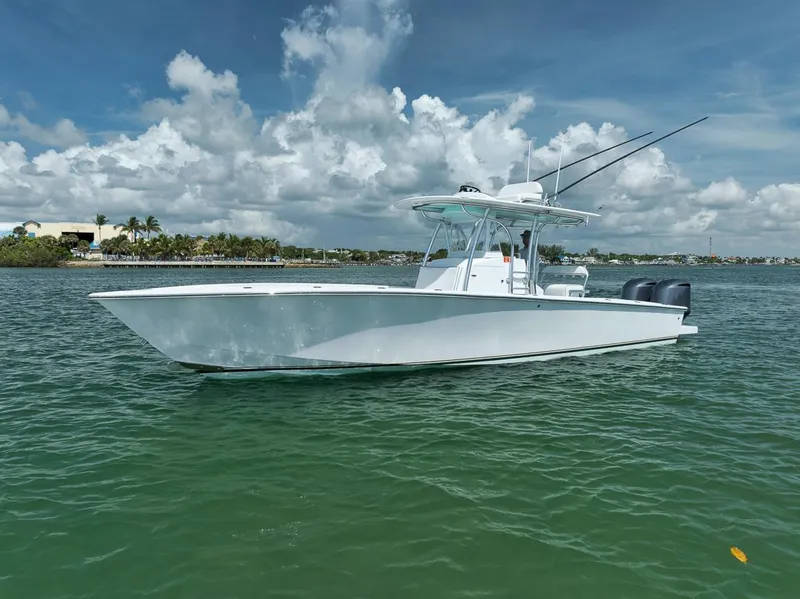 Slide: The Image of 1995 Jupiter 31 Center Console boat on calm water under a partly cloudy sky. - 34