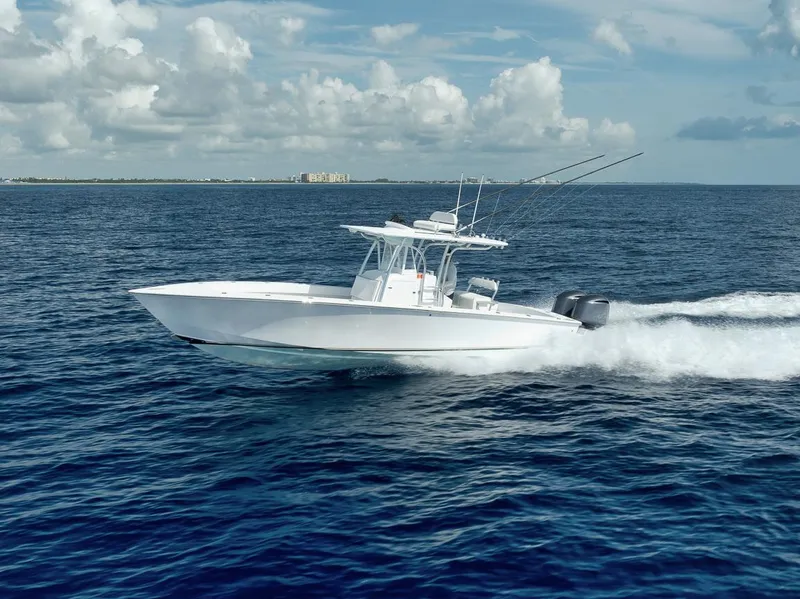 Slide: The Image of 1995 Jupiter 31 Center Console boat cruising on open ocean under blue sky. - 35