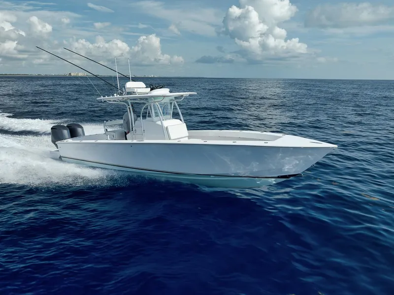 Slide: The Image of 1995 Jupiter 31 Center Console boat cruising on open ocean under blue sky. - 36