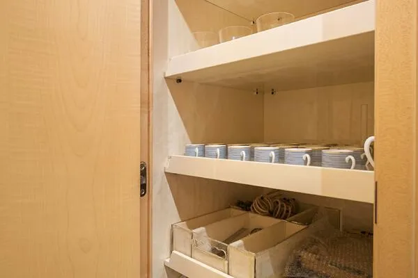 Slide: The Image of Wooden cabinet with neatly arranged cups and storage boxes on shelves. - 32