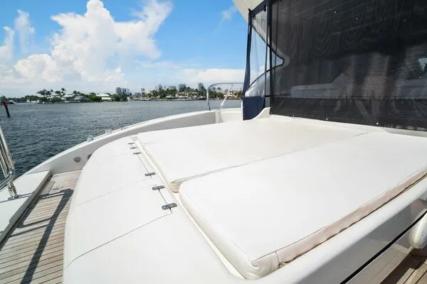 Slide: The Image of Luxurious 2001 Mangusta 72 Open yacht with spacious sunbathing deck, docked by scenic waterfront. - 7
