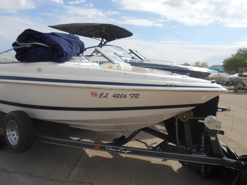 Slide: The Image of 2000 Chris-Craft 200 Bowrider SS on trailer, parked outdoors under cloudy sky. - 14