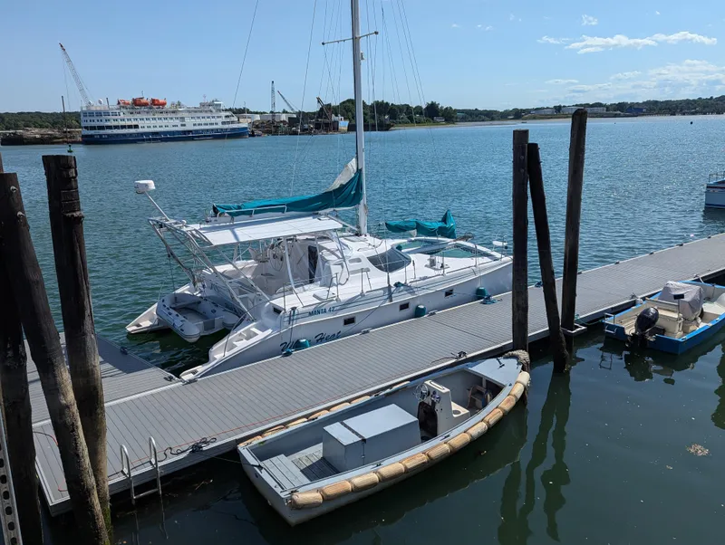 The Image of Manta 42 catamaran docked at marina, 2000 model, with scenic waterfront view. - 1