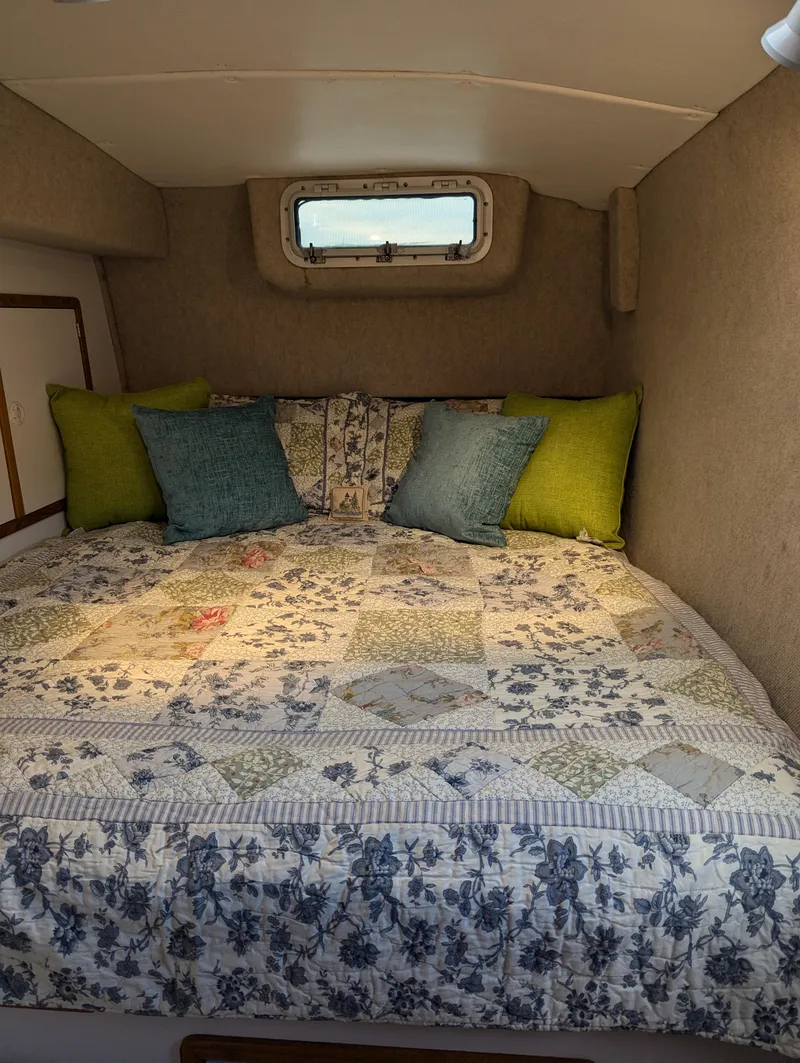 Slide: The Image of Cozy cabin bed in 2000 Manta 42 sailboat with floral quilt and colorful pillows. - 11