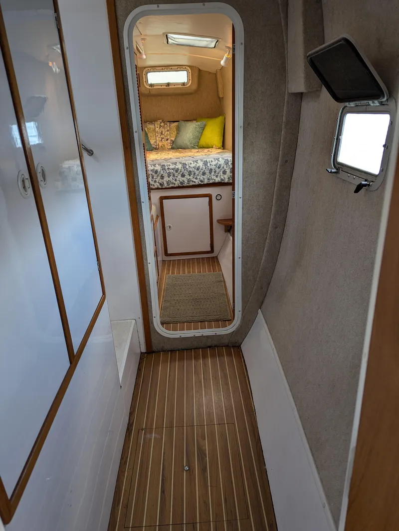 Slide: The Image of Narrow hallway in a 2000 Manta 42 yacht, leading to a cozy cabin with a bed. - 15