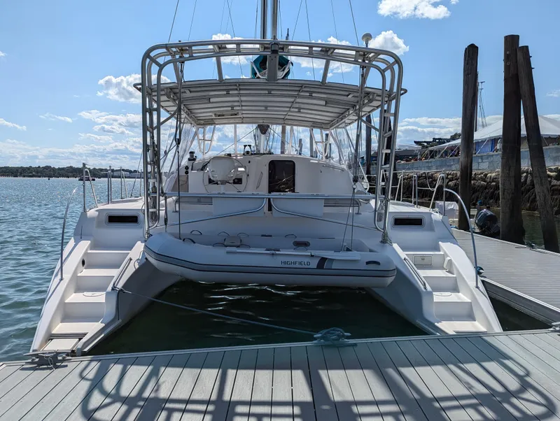 Slide: The Image of Manta 42 catamaran, 2000 model, docked at a marina under a clear blue sky. - 2