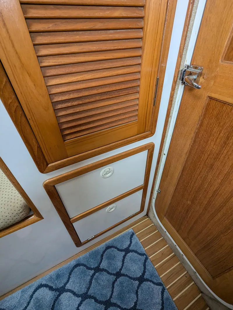 Slide: The Image of Interior of 2000 Manta 42 boat with wooden cabinets and blue patterned rug. - 22
