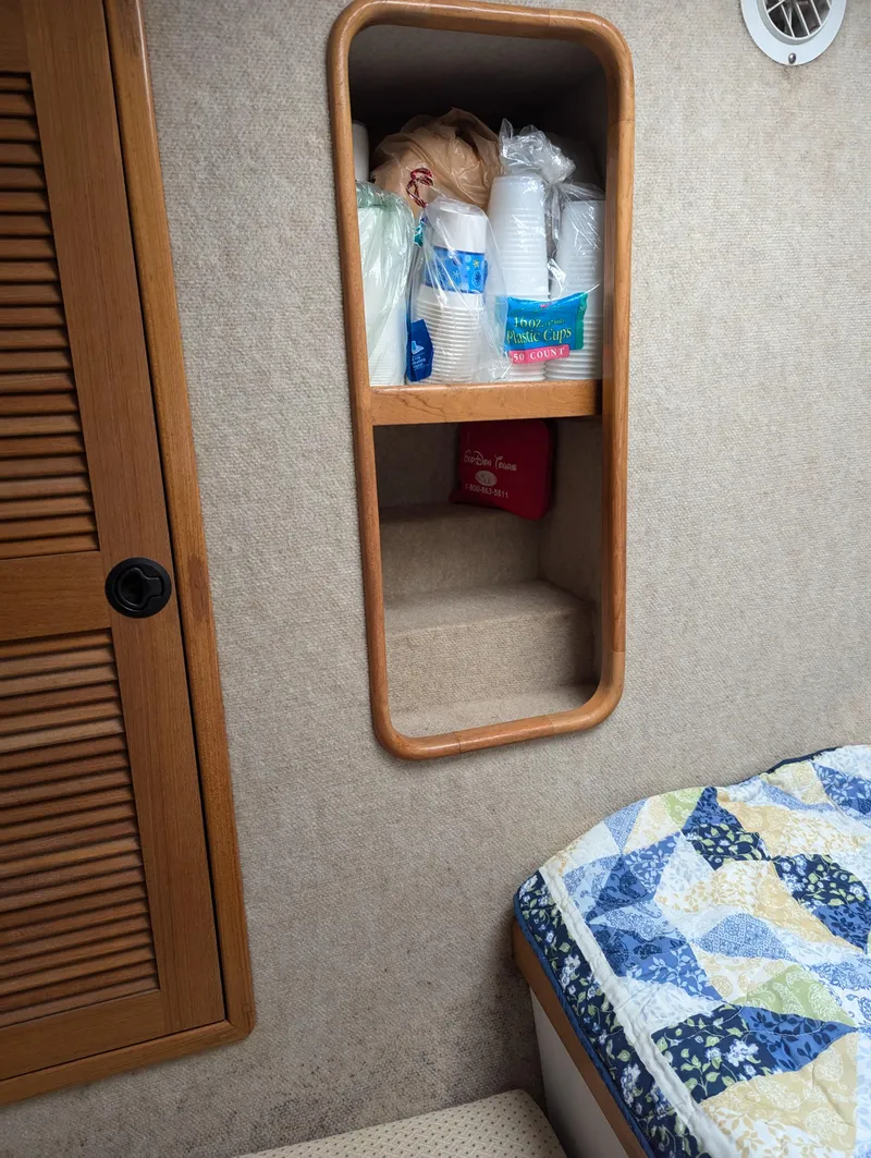 Slide: The Image of Interior of a 2000 Manta 42 boat with storage shelves and a quilted bed. - 25