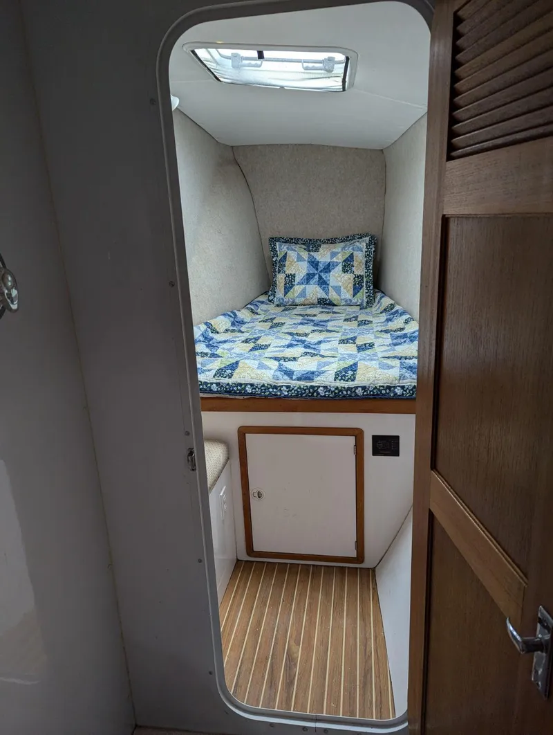 Slide: The Image of Cozy cabin interior of 2000 Manta 42 sailboat with quilted bedding and wooden flooring. - 31