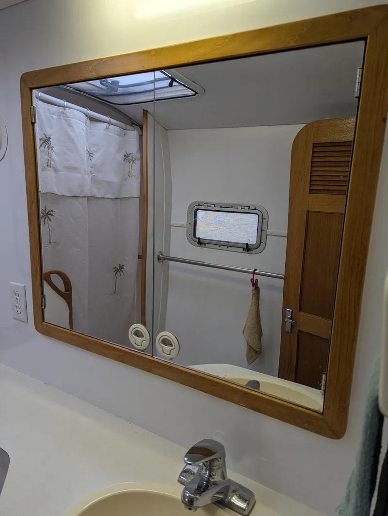 Slide: The Image of Bathroom mirror reflection in a 2000 Manta 42 yacht, showing shower and porthole. - 32