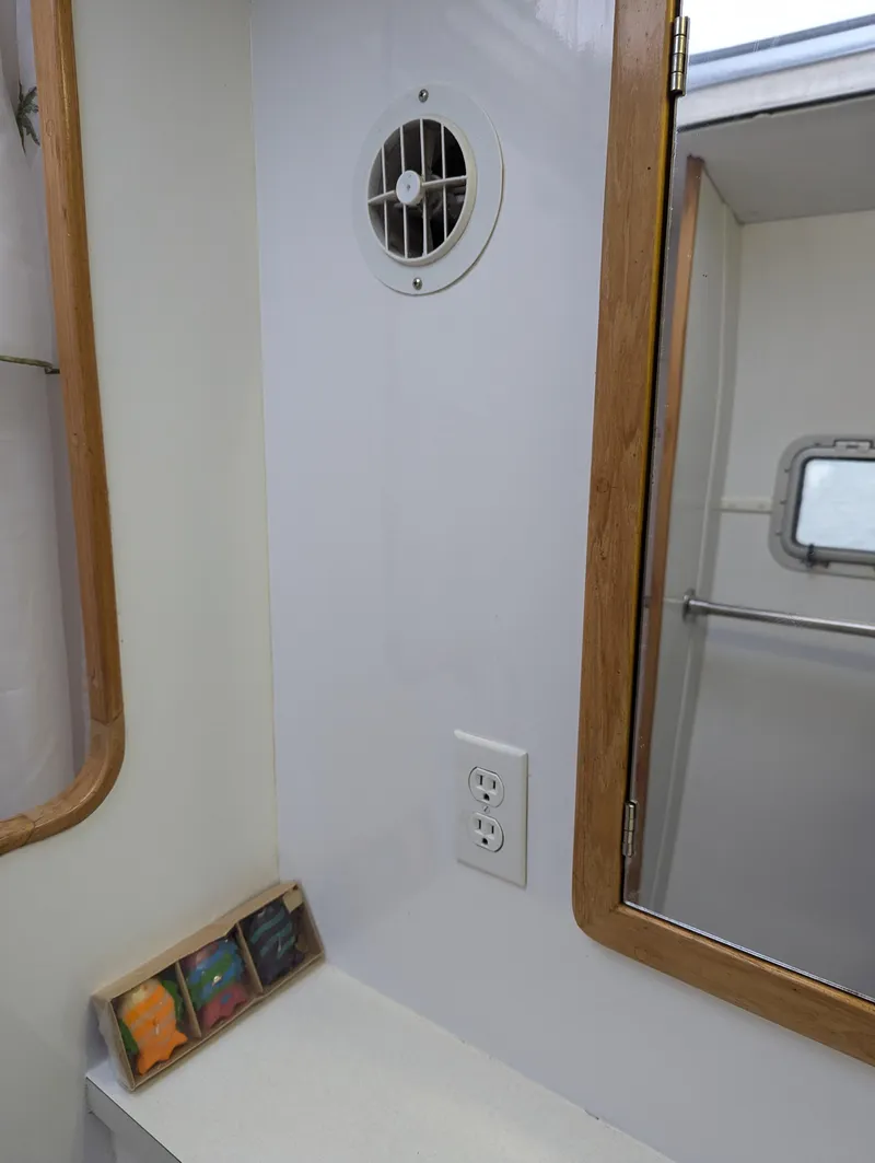 Slide: The Image of Interior of a 2000 Manta 42 boat, featuring a bathroom with a vent and mirror. - 36