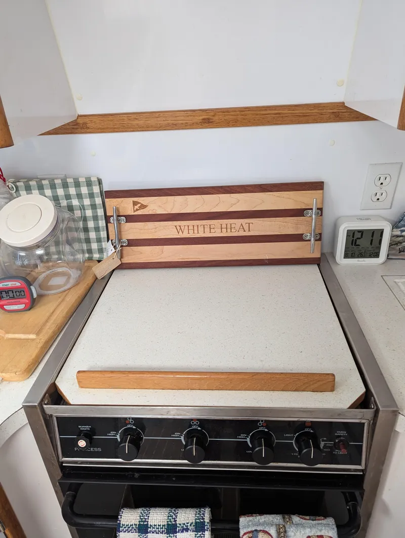 Slide: The Image of Stove with wooden cover labeled "White Heat" on a Manta 42, 2000 model. - 38