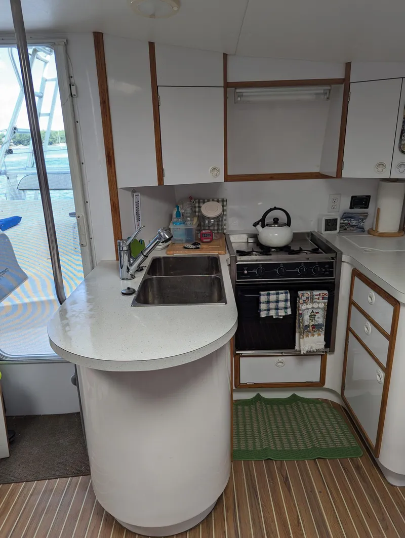 Slide: The Image of Compact kitchen in a 2000 Manta 42 yacht with modern amenities and wooden flooring. - 40