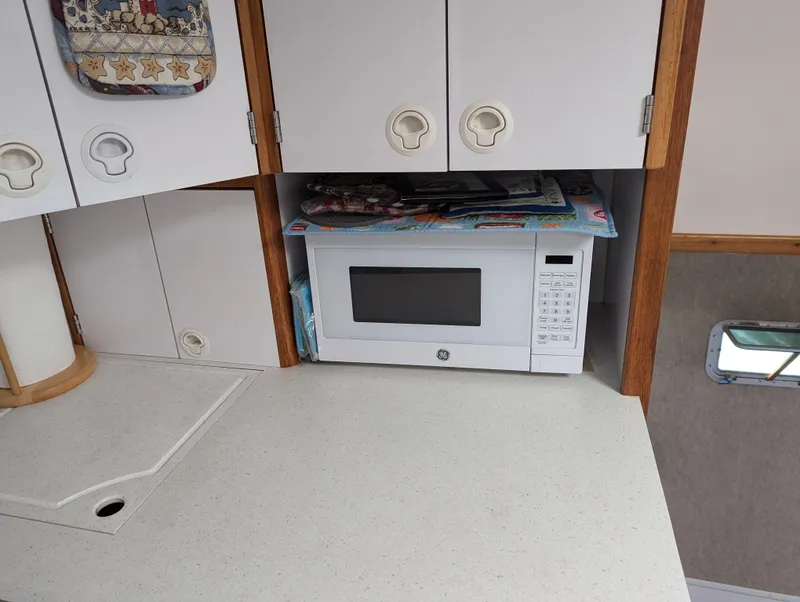Slide: The Image of Compact kitchen area in a 2000 Manta 42, featuring a built-in microwave. - 42