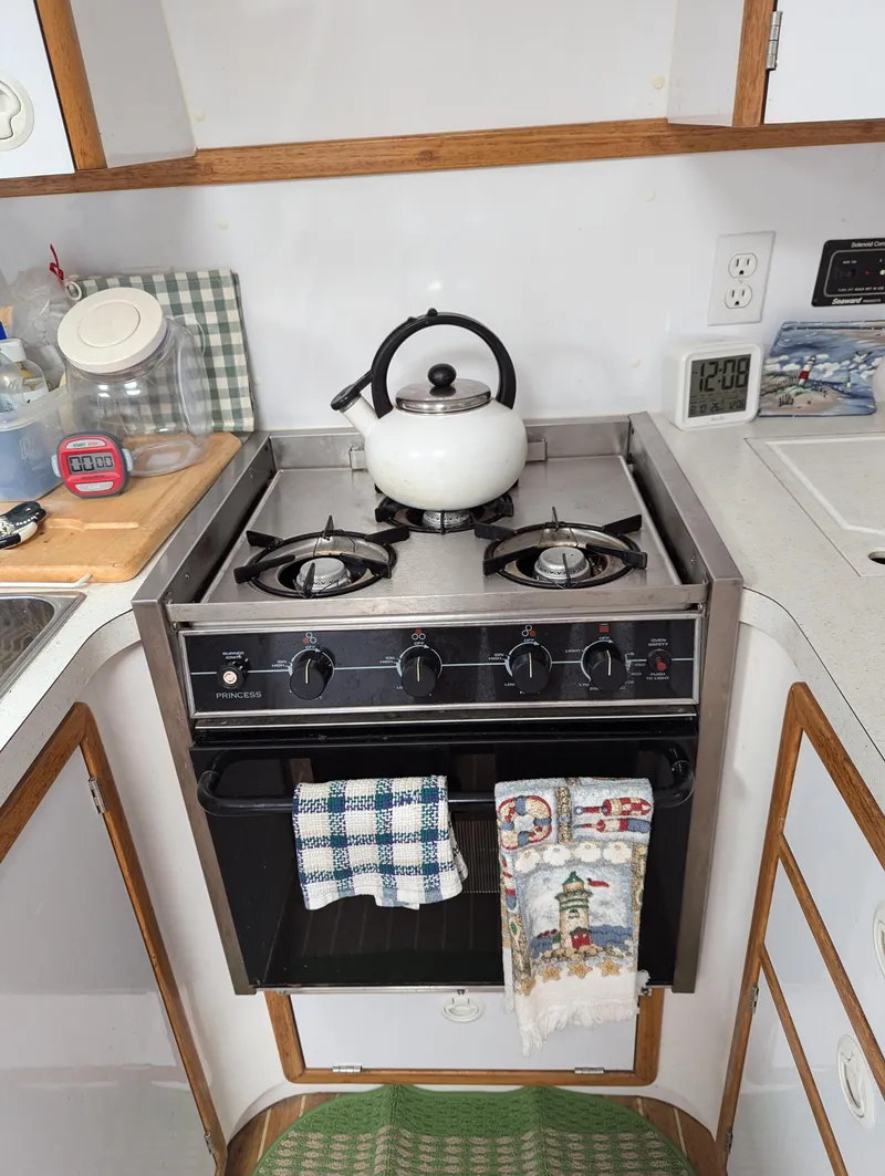 Slide: The Image of Compact kitchen with a gas stove, kettle, and towels in a 2000 Manta 42. - 44