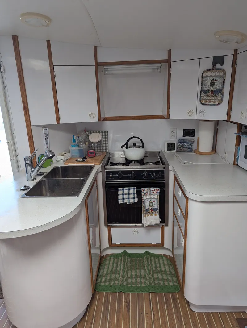 Slide: The Image of Compact kitchen in a 2000 Manta 42 yacht with modern appliances and white cabinetry. - 45