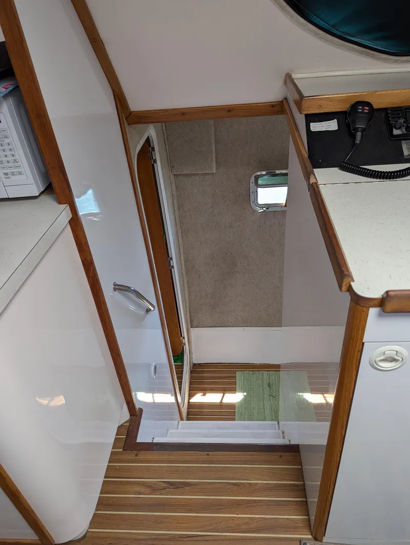 Slide: The Image of Interior view of 2000 Manta 42 boat, featuring wooden flooring and compact design. - 46