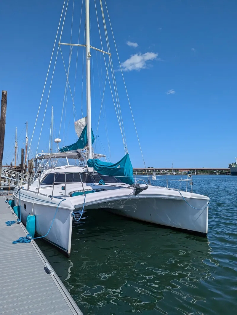 Slide: The Image of 2000 Manta 42 catamaran docked at marina under clear blue sky. - 5