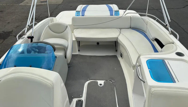 Slide: The Image of 2006 Bayliner 217 boat interior with white and blue seating, steering wheel, and storage compartments. - 11