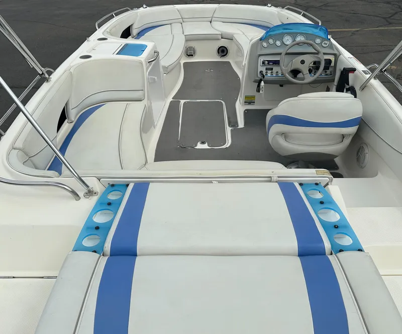 Slide: The Image of 2006 Bayliner 217 boat interior with blue and white seating and dashboard. - 12