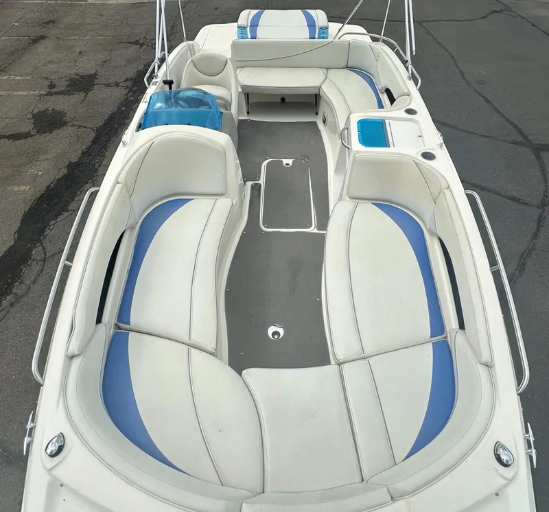 Slide: The Image of 2006 Bayliner 217 boat interior with white and blue seating, spacious layout. - 5