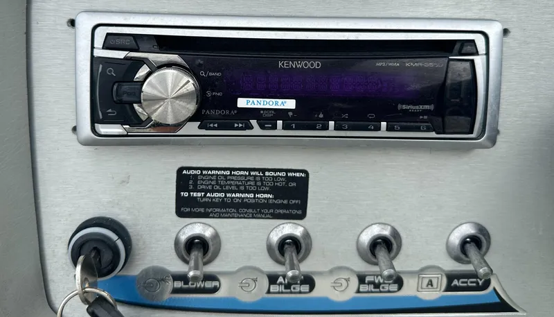 Slide: The Image of Kenwood stereo system on 2006 Bayliner 217 boat dashboard with control switches. - 7