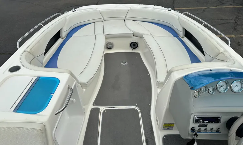 Slide: The Image of 2006 Bayliner 217 boat interior with white and blue seating, dashboard, and controls. - 8