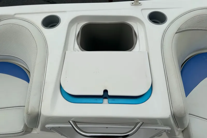 Slide: The Image of 2006 Bayliner 217 boat seating area with cup holders and storage compartment. - 9