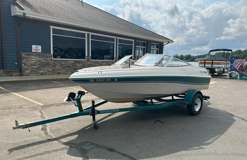 Slide: The Image of 1997 Four Winns Horizon QX boat on trailer, parked outside a building. - 1