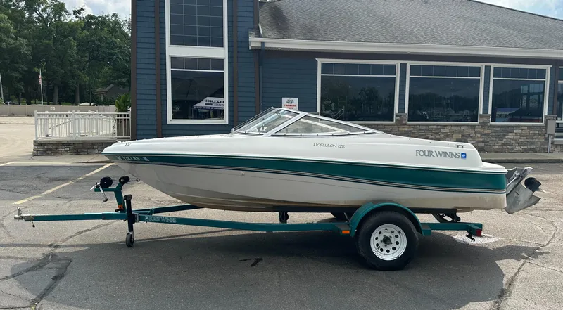 Slide: The Image of 1997 Four Winns Horizon QX boat on trailer, parked outside a building. - 2
