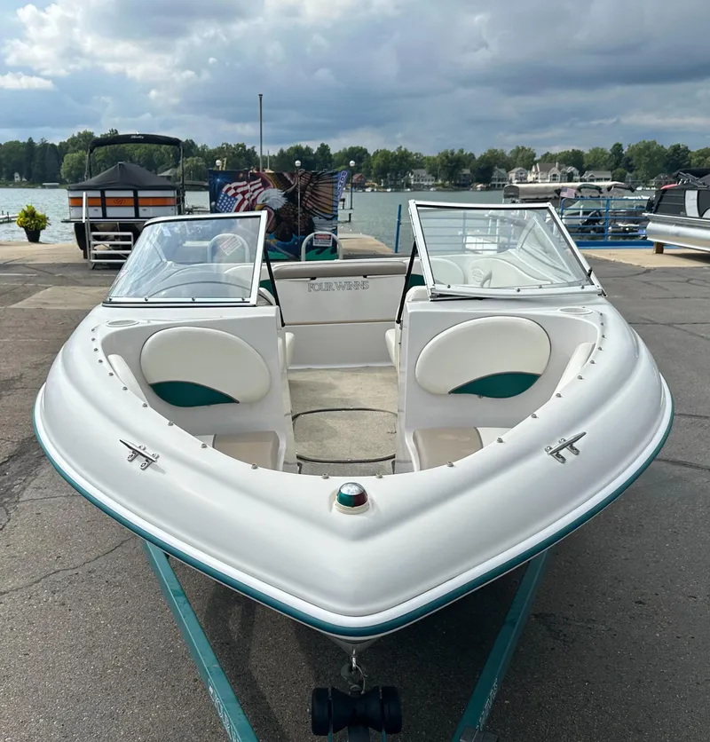 Slide: The Image of 1997 Four Winns Horizon QX boat docked by a lake under cloudy skies. - 3